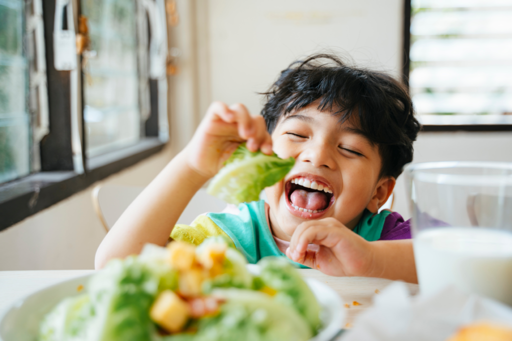 happy boy eating lettuce